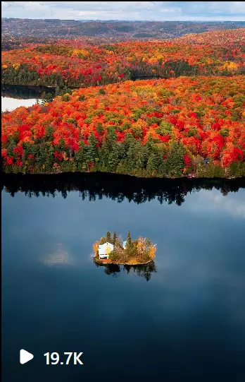 a small island in a lake surrounded by trees with Fall colors