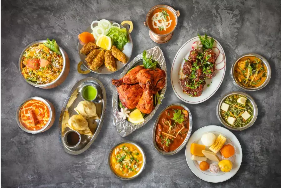 a table topped with lots of different types of Indian food all made by Madhuban Indian Cuisine in Ottawa